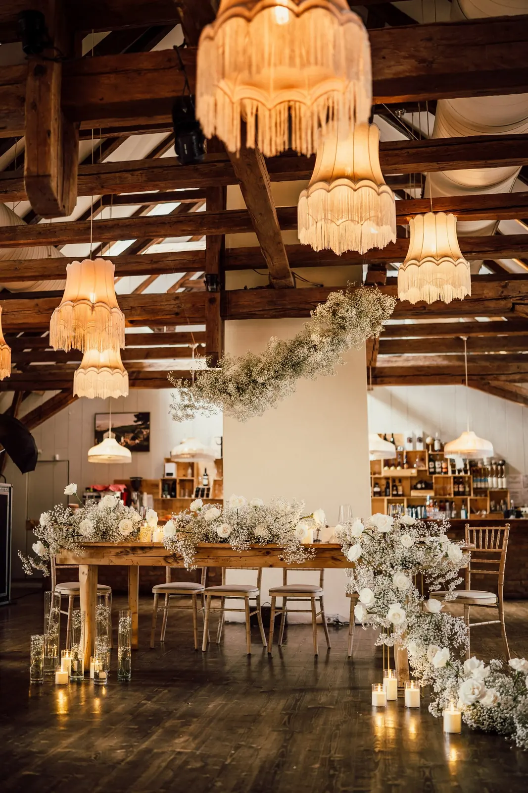 Sală rustică decorată cu gypsophila, lumânări și masă lungă